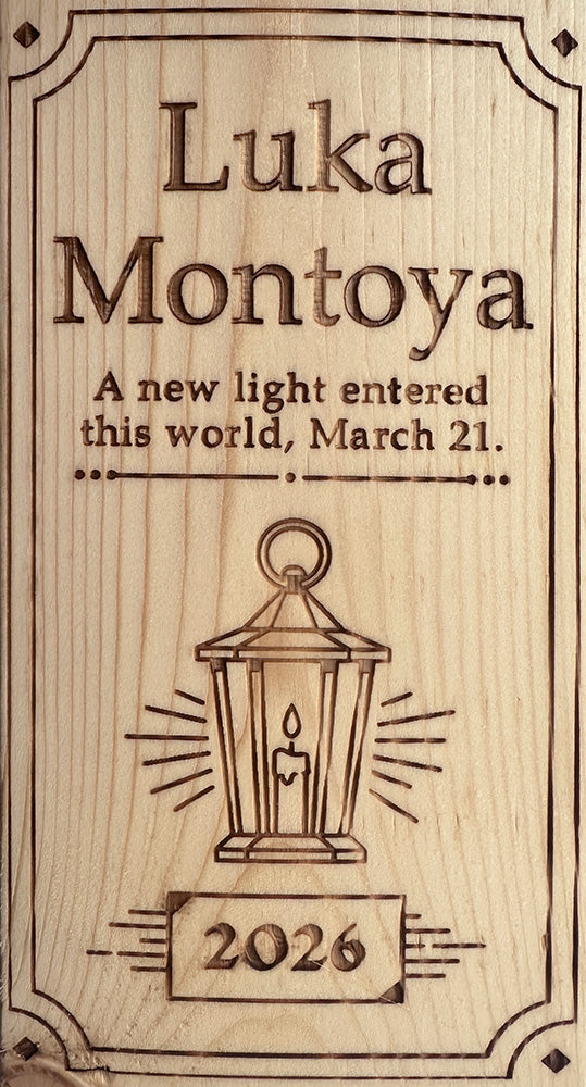 Wooden plaque with engraved text and a lantern design, featuring the name Luka Montoya and a date.